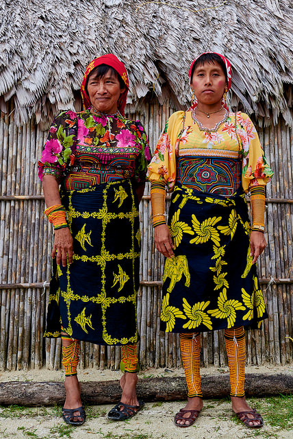 Guna women in traditional dress.  Note mola panels on the front of their shirts.   And wini beads around their legs